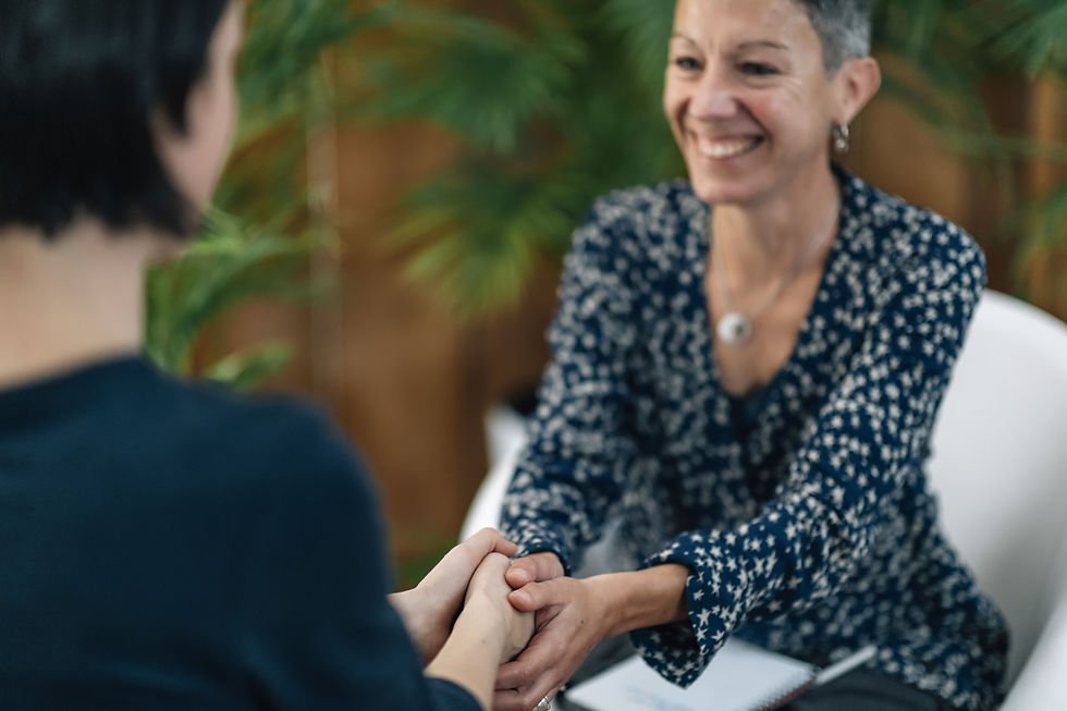 Twee vrouwen in gesprek waarbij één de handen van de ander vasthoudt, passend bij RTT en hypnotherapie.