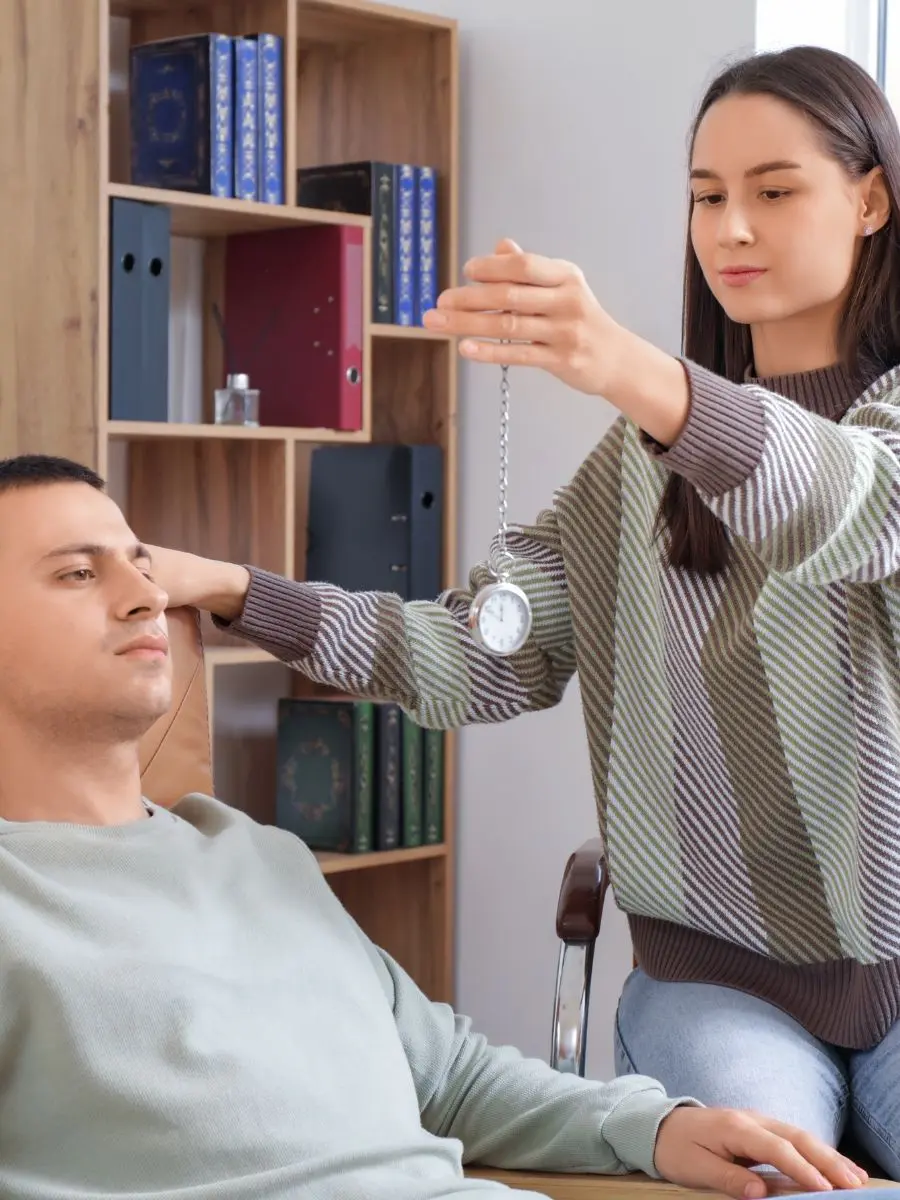 Hypnotherapie Alkmaar: hypnotherapeut begeleidt een cliënt met een pendel tijdens een hypnosesessie